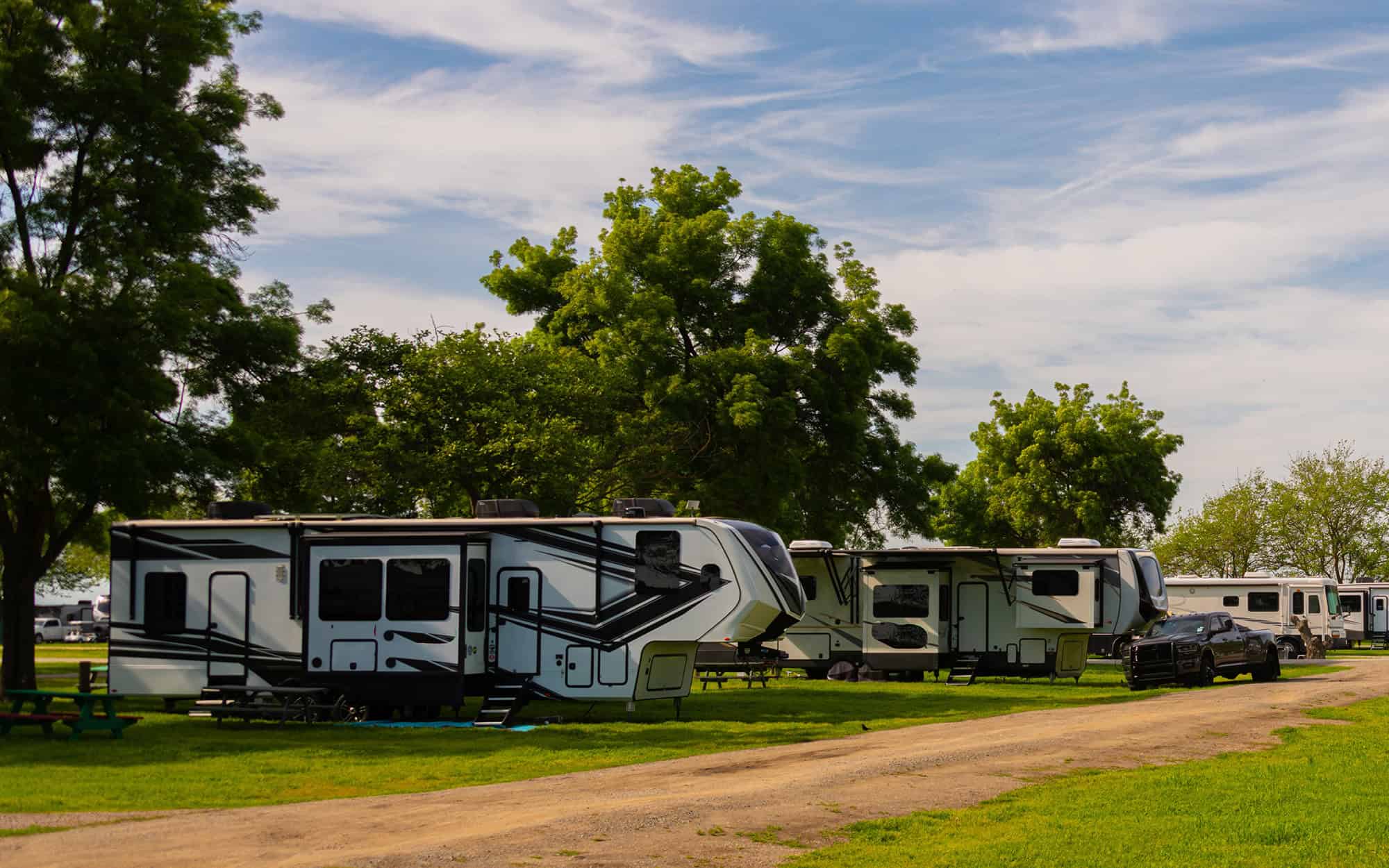 Large Rv trailers parked at campsite on grass