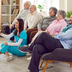 Assisted living seniors watching tv together